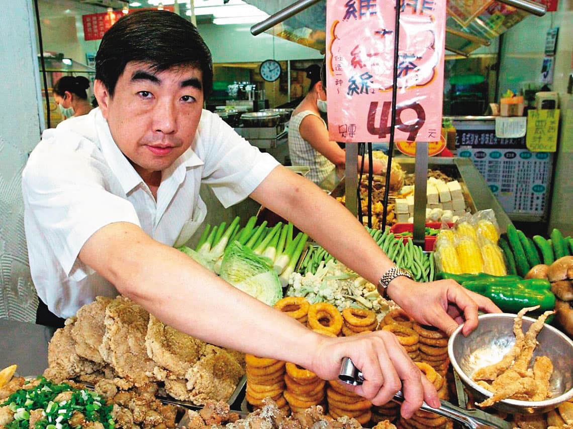 早期的台灣鹽酥雞只是一家小攤店,洪誌謙認真經營,穿著也很整齊。(台灣鹽酥雞提供)