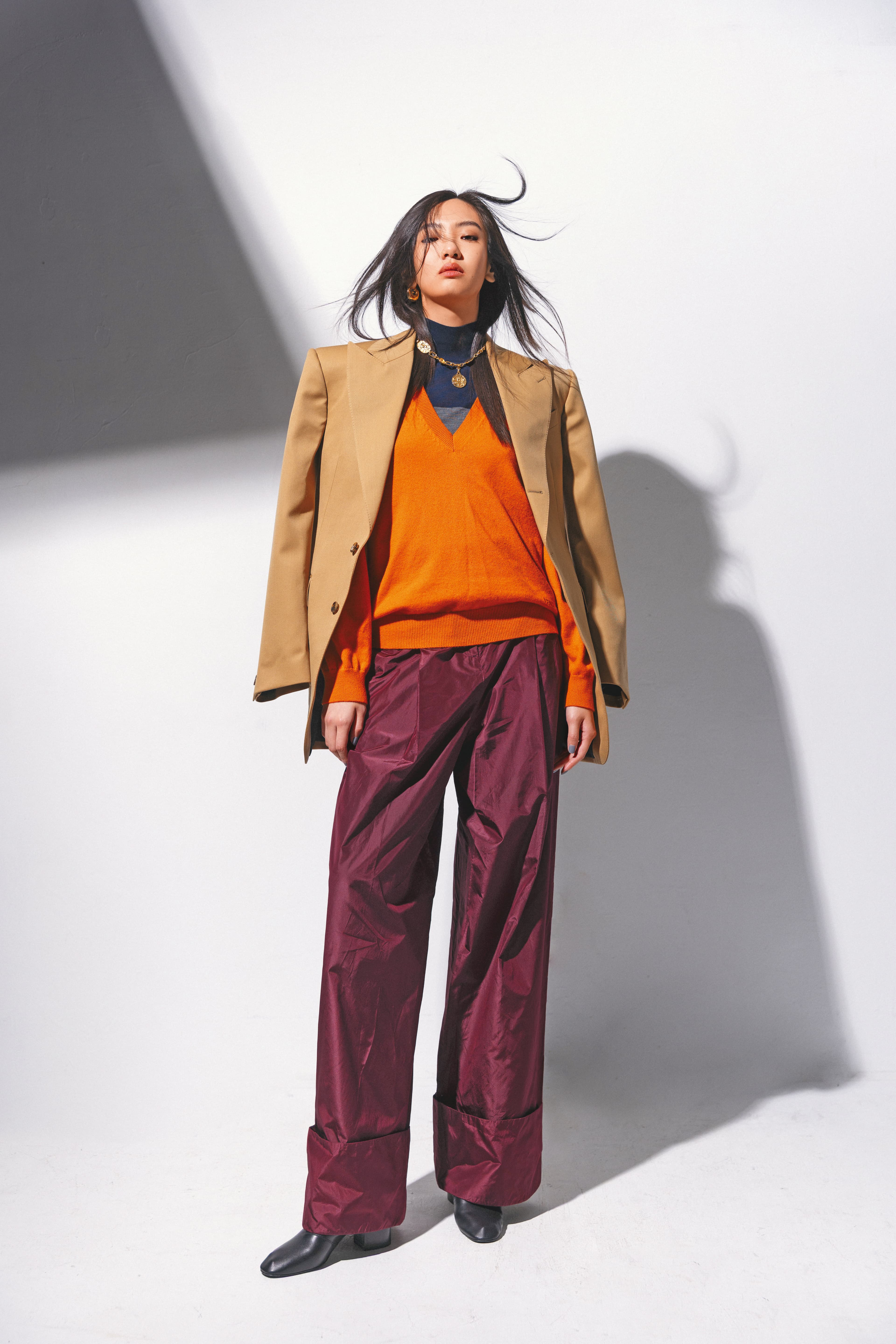 COLONNE夾克 NT$112,000 by CELINE；橙色羊絨毛衣 NT$61,200 by FENDI；雙色（深灰色／藍色）高領衣 NT$36,900 by FERRAGAMO；勃根地酒紅色塔夫綢長褲 NT$78,000 by FENDI；羊皮革短靴 價格店洽 by CELINE；GUCCI Bondie系列耳環 NT$30,700 by GUCCI；金色項鍊 價格店洽 by Chloé。