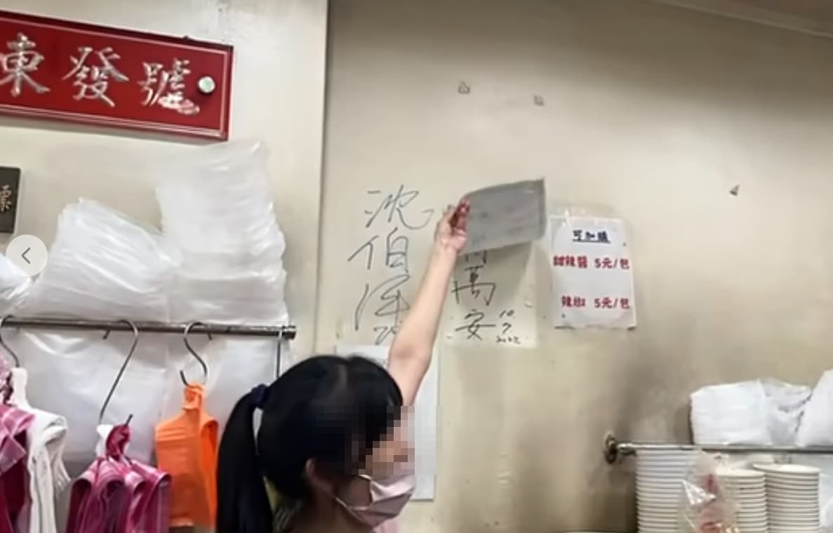 沈伯洋光顧百年老店「東發號麵線」時,店家邀請他幫忙簽名,並掀開「蓋住」許久的蔣萬安簽名。(翻攝自周軒臉書)