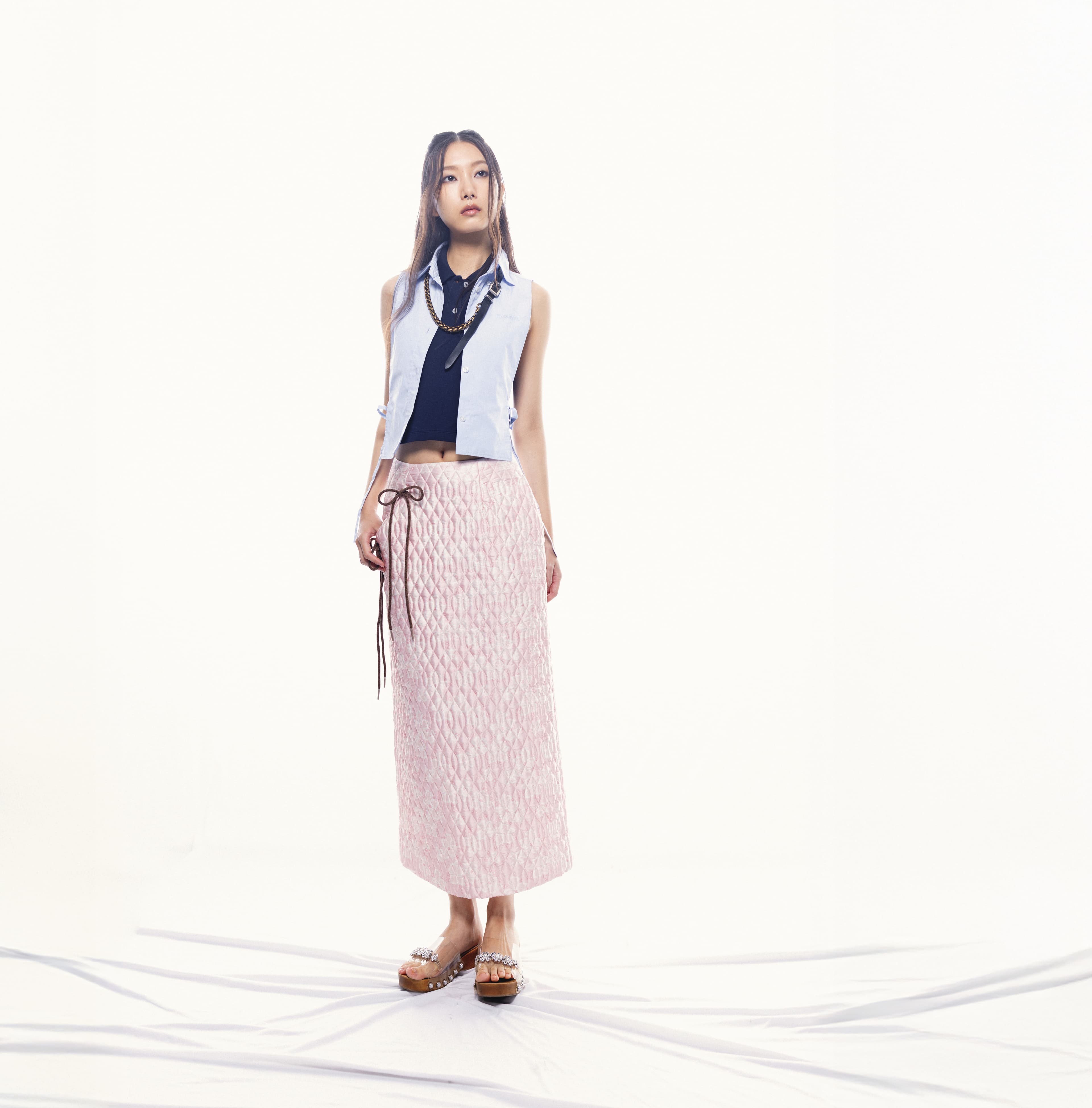 水藍背心襯衫 價格店洽 by MIU MIU;深藍背心針織上衣 價格店洽 by MIU MIU;粉色菱格不對稱鉛筆裙 NT$30,800 by Simone Rocha;珍珠裝飾透明果凍木屐鞋 NT$27,800 by Simone Rocha;皮革鍊條項鍊 價格店洽 by MIU MIU。