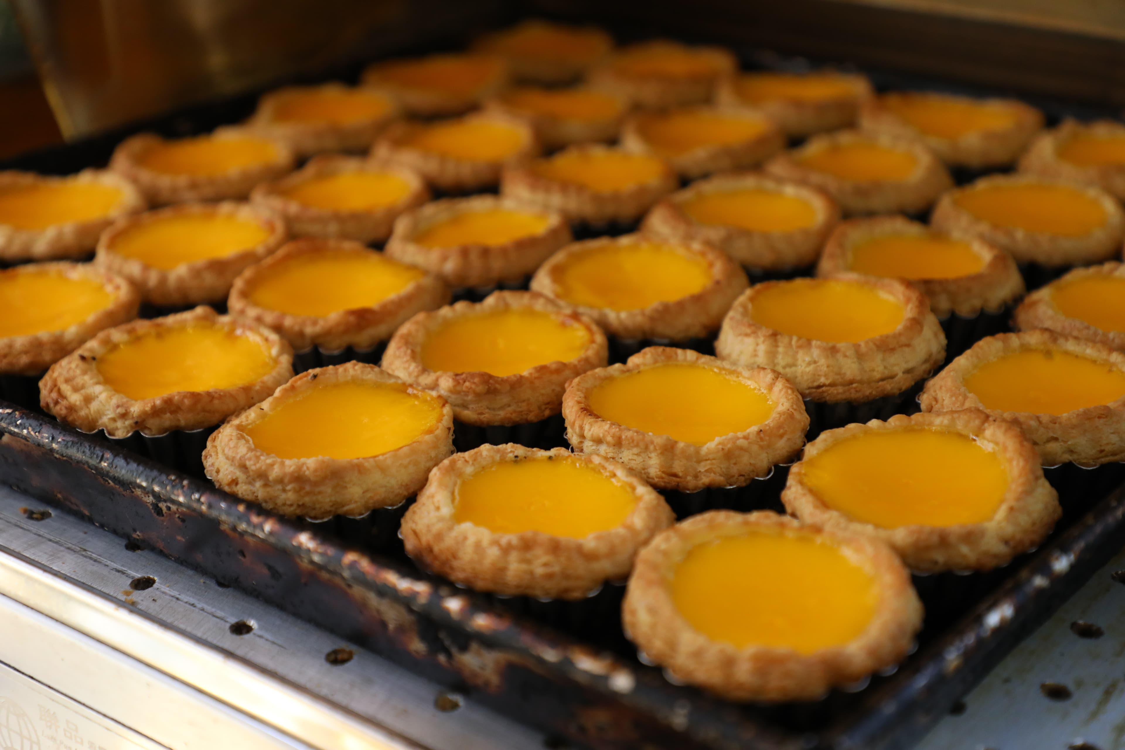 剛出爐的「馳名酥皮蛋塔」香氣四溢,蛋液香濃,酥皮鬆化。(港幣10元/個)