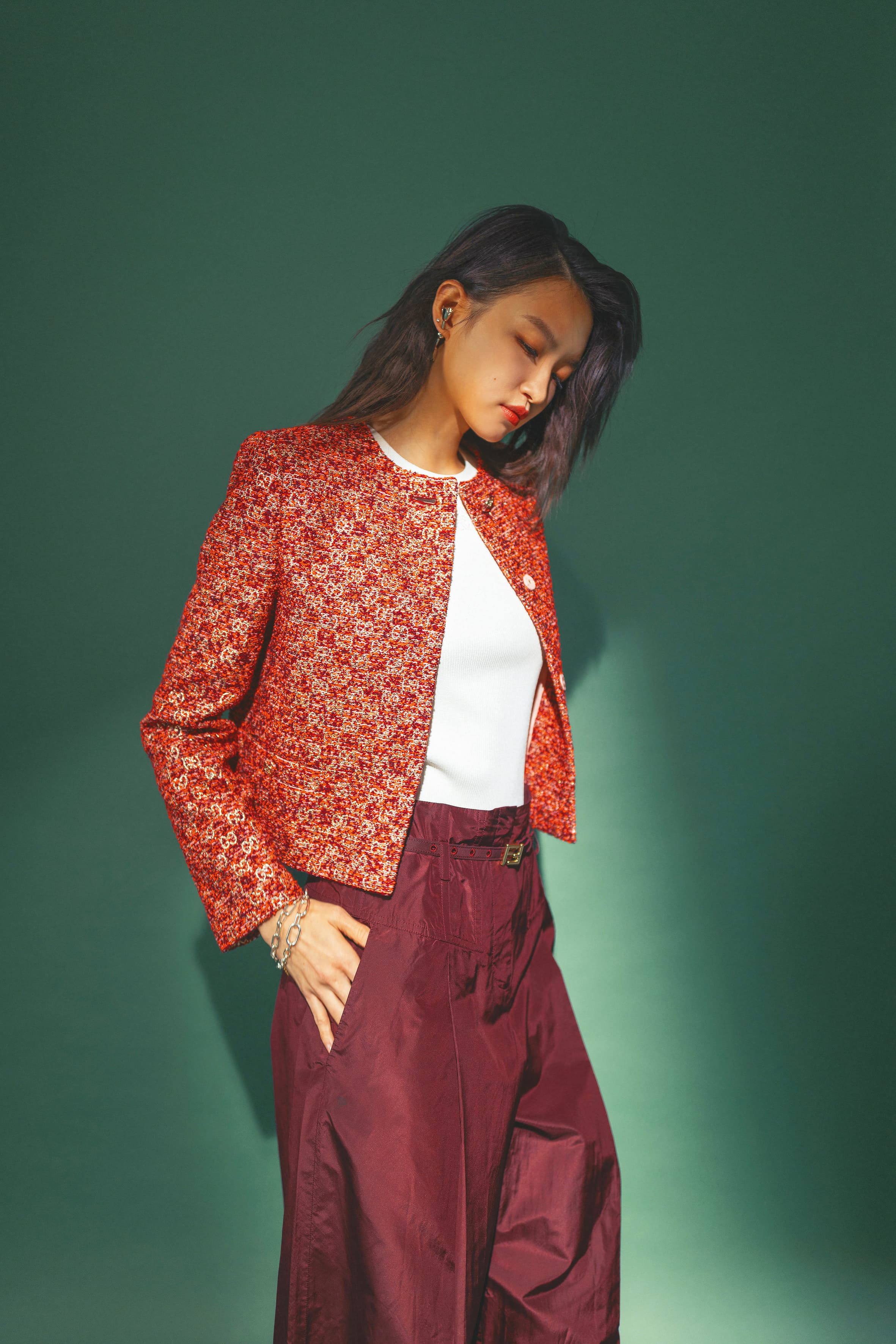 紅色針織短版外套 NT$117,000 by GUCCI；白色彈性嫘縈Anagram無袖上衣 NT$31,000 by LOEWE；勃根地酒紅色塔夫綢長褲 NT$78,000 by FENDI；花朵造型耳環 價格店洽 by Simone Rocha；（上）人工淡水養殖珍珠手鍊 NT$5,880 by PANDORA；（下）特大鏈圈手鍊 NT$4,380 by PANDORA。