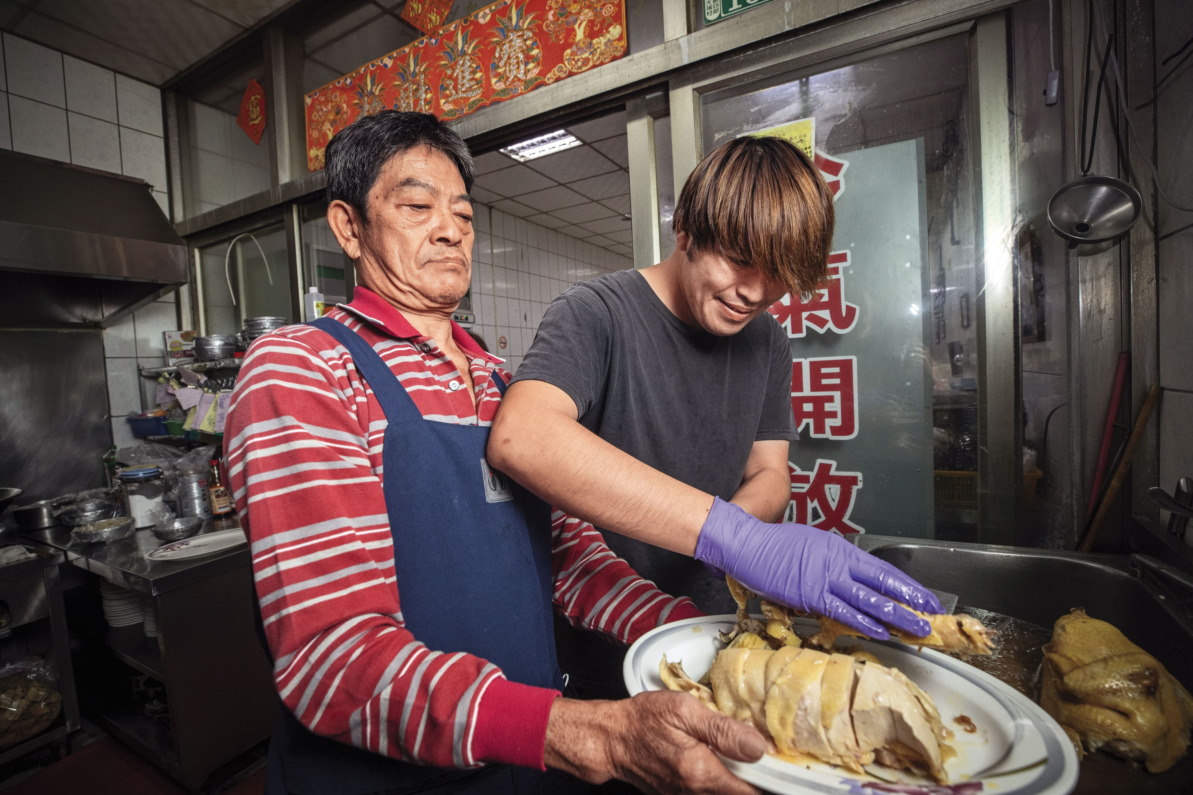 自家養的白斬雞亦是佳香的招牌菜,江明苓老公羅吉鎮(左)與次子羅偉壬(右)負責砧板備菜。