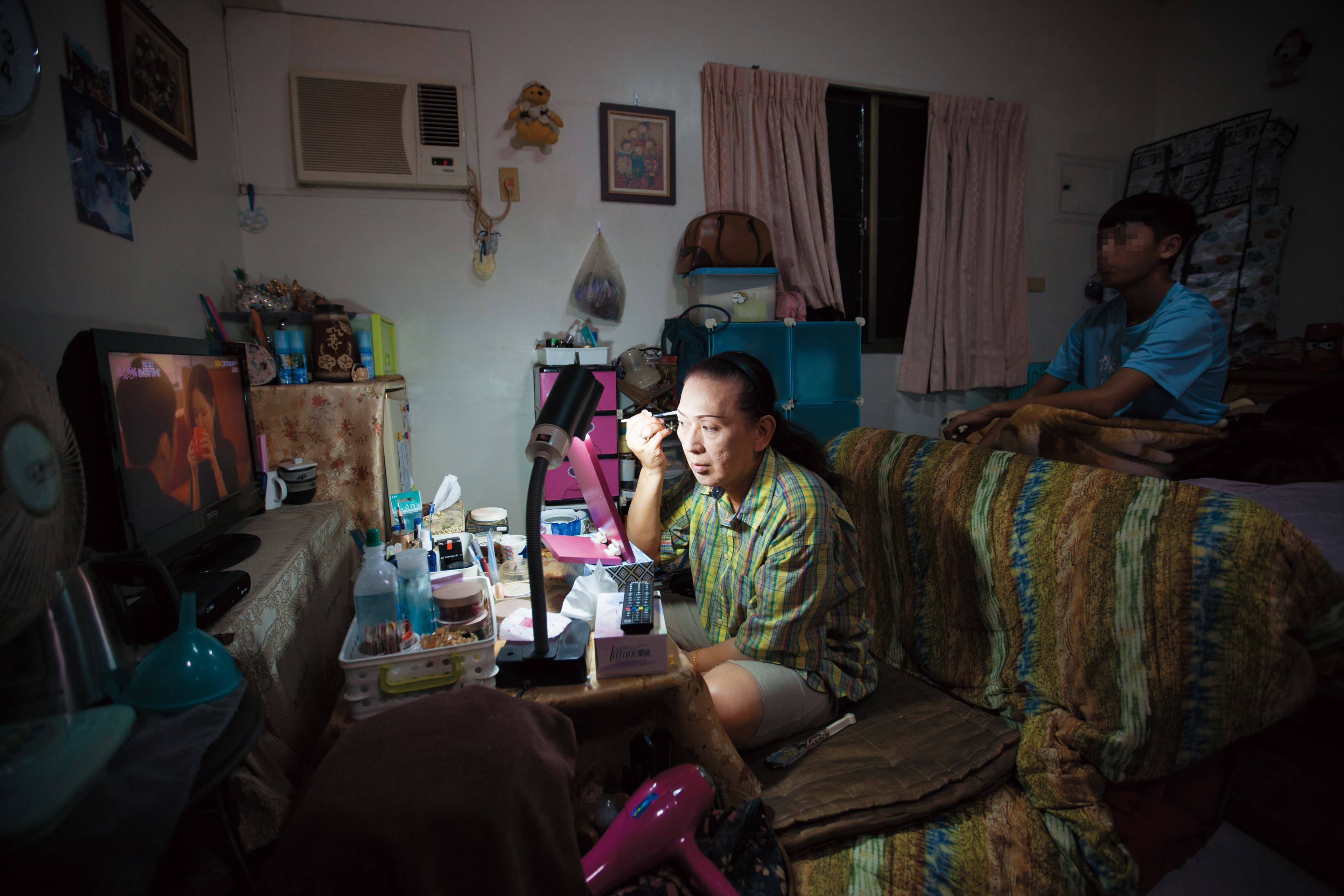鍾玲(左)正在化妝。她說自己化妝一定要開電視,透露了寂寞的日子,需要一點聲音陪伴。