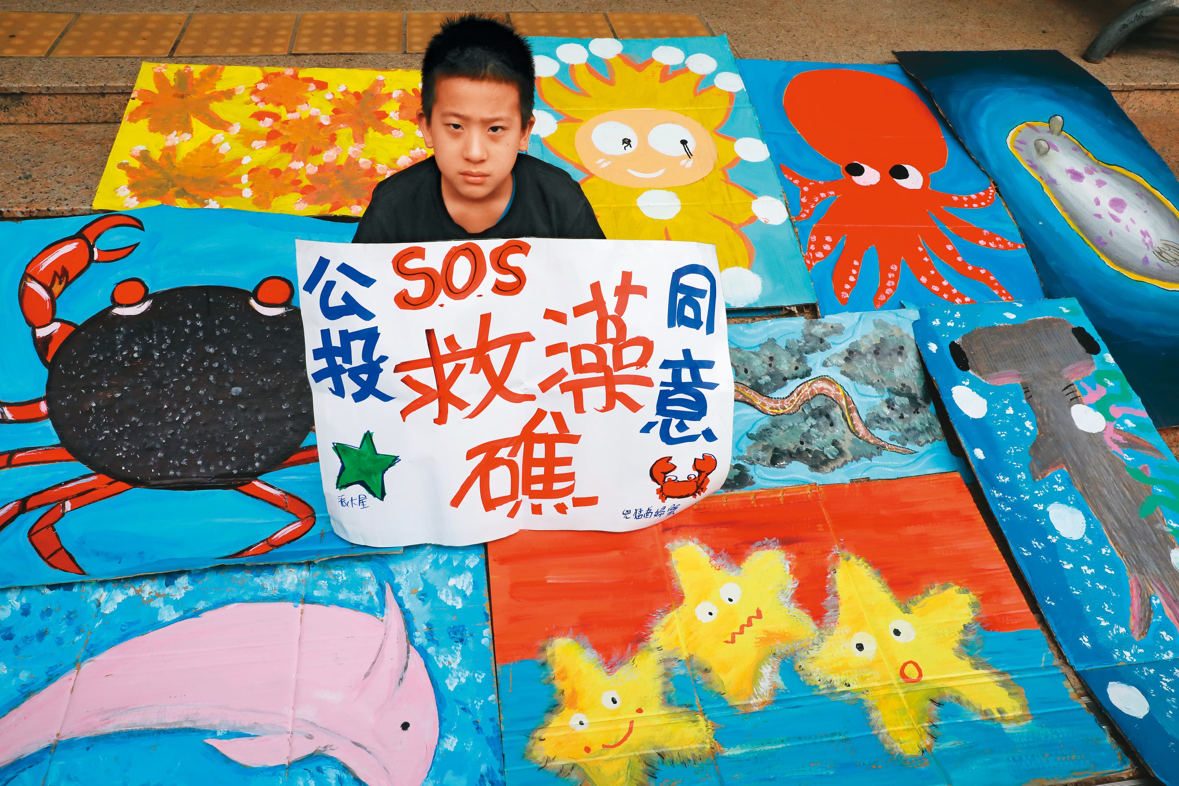 圖為藻礁公投推動聯盟12月5日於立院外舉行記者會,小學生展示藻礁生態系中各種生物的繪圖作品。