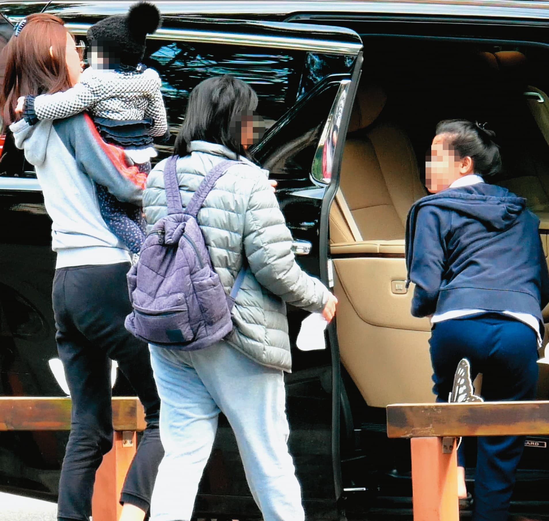 在外玩耍一陣子後,錢帥君(左)抱著小孩回到車上。