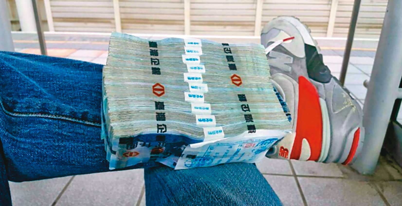 為了取信被害人,張錦生故意將大筆現金放在腳上拍照炫富。(讀者提供)