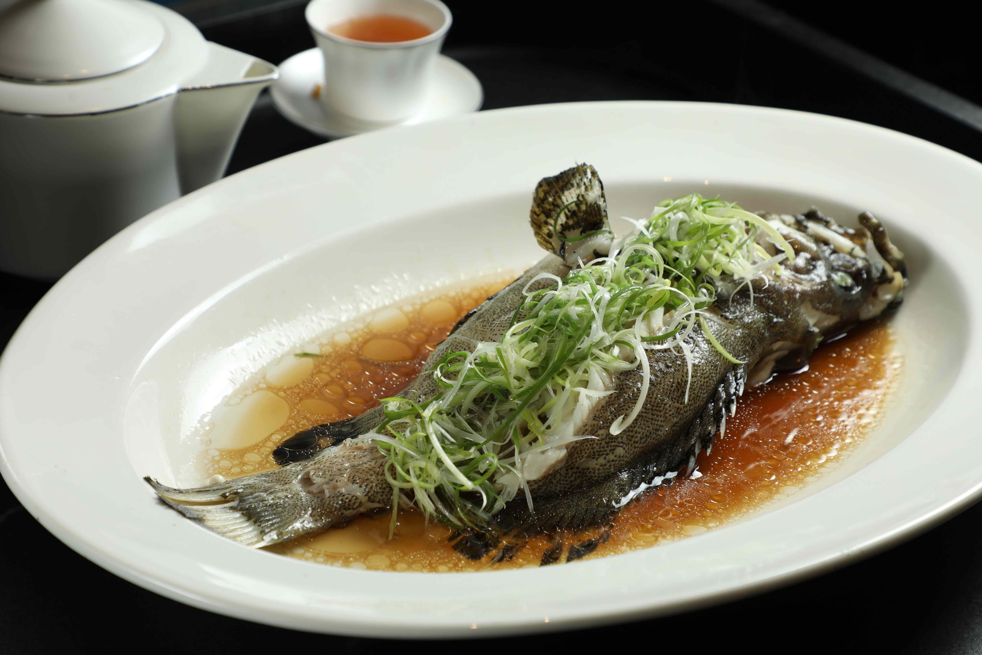 「蔥油清蒸活龍虎斑」以蔥油提香,凸顯龍虎斑鮮嫩細緻的肉質。(時價)