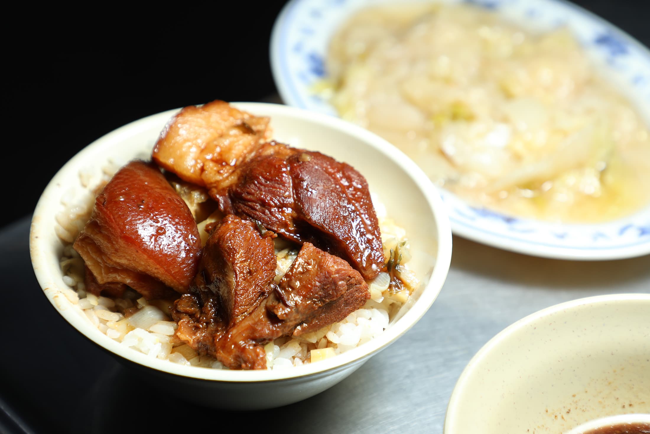 「焢肉飯」（前，60元／份）放上幾塊帶皮肥肉與瘦肉，米飯淋上醇厚滷汁，再點份「滷白菜」（後，35元／份），就是簡單卻讓人感到滿足的組合。