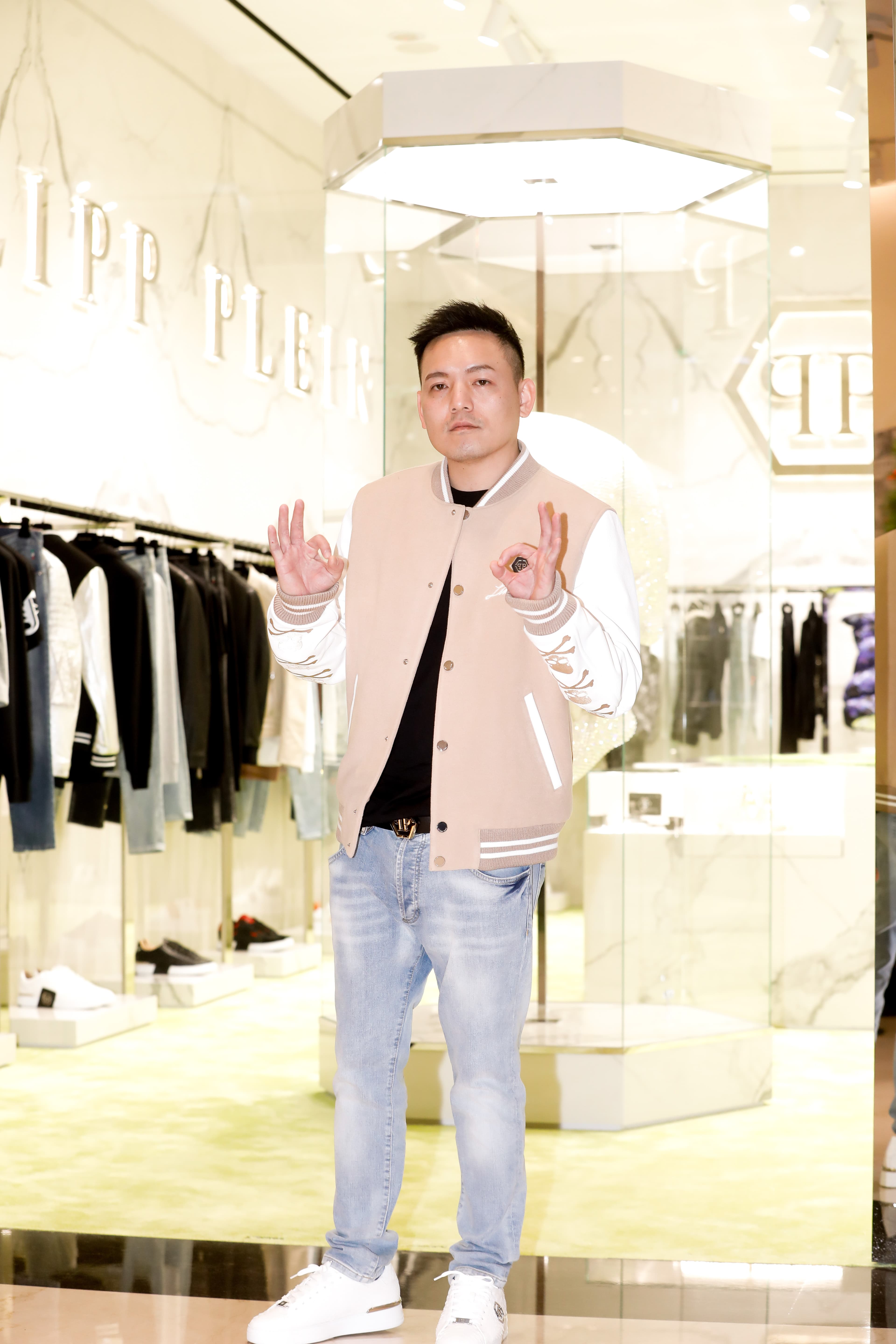 春風身著PHILIPP PLEIN棒球外套(NT$136,750)、丹寧牛仔褲(NT$34,310),搭配蟒蛇壓紋球鞋(NT$59,580)。