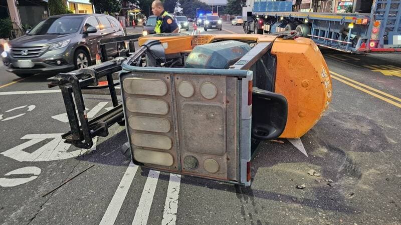 聯結車載運巨型堆高機竟在行駛中突然傾倒滾落。(屏東警分局提供)