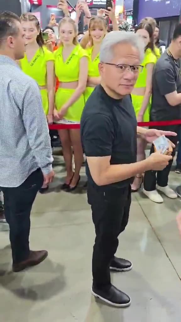 黃仁勳拿出千元鈔票,簽名前看了一下皮夾的主人,表情相當逗趣。(翻攝hkepc Threads)