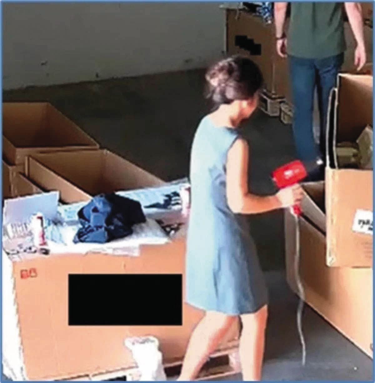 美方根據監視器掌握,不法集團利用吹風機熱風將紙箱標籤改標,盜賣輝達高階晶片至中國謀取暴利。(翻攝美國司法部官網)
