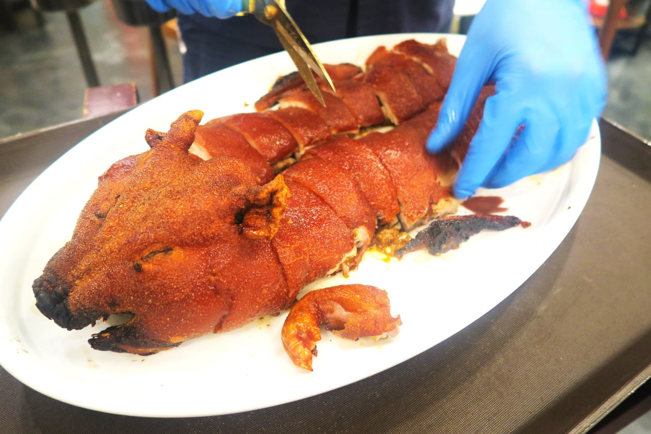 乳豬趁熱連骨剪成一塊塊,迅速分食享用。(堂剪迷你乳豬,港幣888元/隻,約NT$3,599,需預訂)