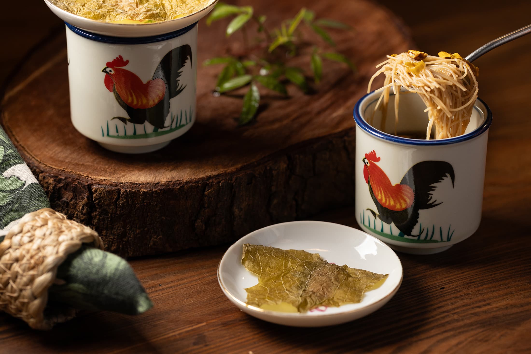 「米粉湯」以峨眉東方美人茶為靈感,湯底由酸菜、蘿蔔乾與10種蔬菜熬出鮮甜,配上柴燒金針花的煙燻感,重塑新竹人記憶中的米粉湯。