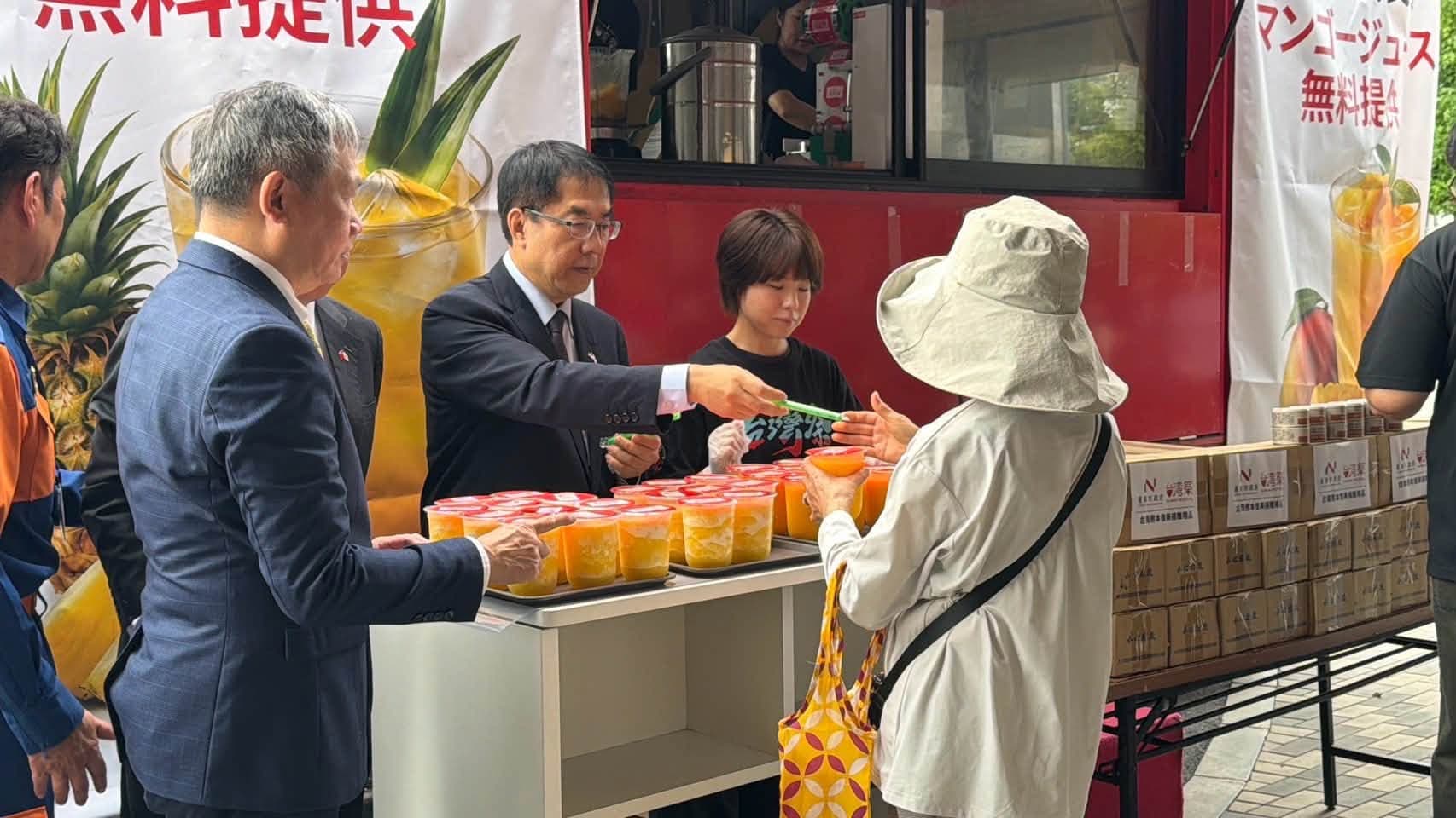 黃偉哲12日上午到熊本的台灣祭行動餐車,親手發放果汁給地震災民。(翻攝自黃偉哲臉書)