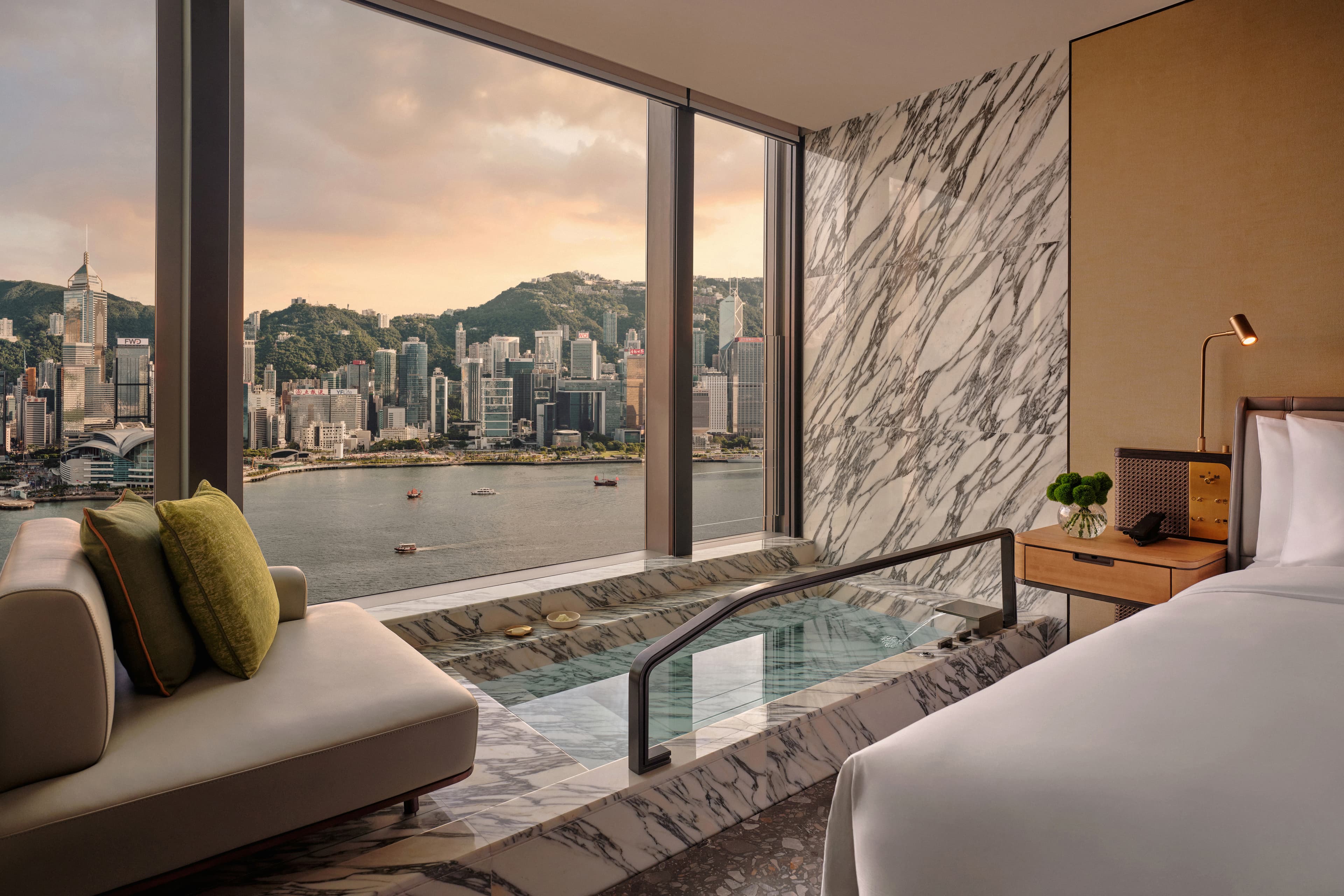 「Kimpton Harbour Suite」的下沉式大理石浴缸就在海景窗邊,同時也緊鄰床側。(尖沙咀金普頓提供)