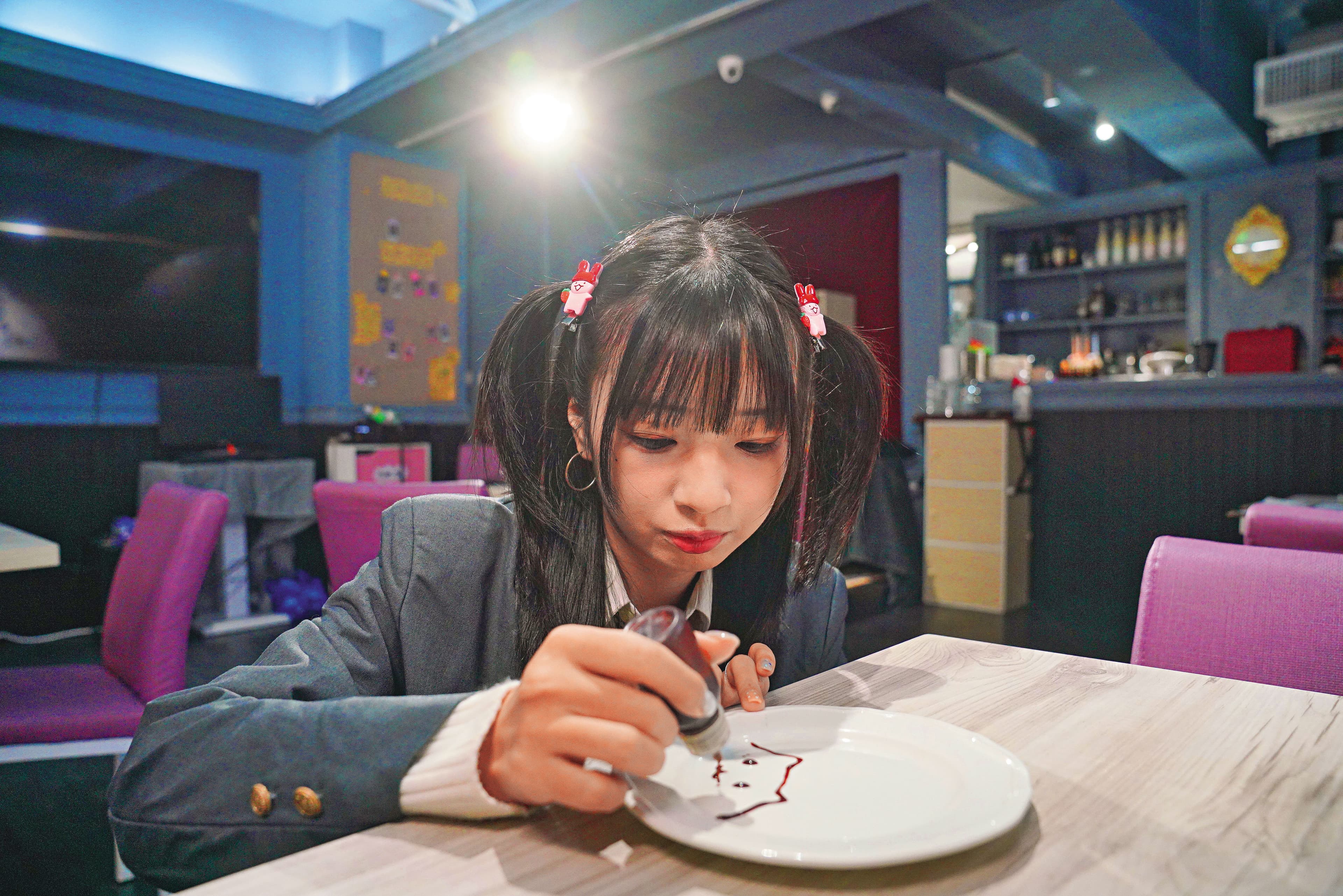 女僕咖啡廳的一大特色就是「繪盤」,由女僕在桌邊用巧克力醬繪製圖案。女僕繪盤蛋糕(150元/份)、心桃文學部(150元/杯)。