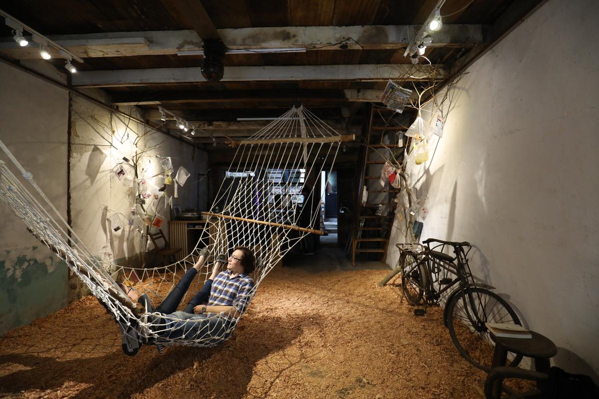 「七沁工作室」從空間到展覽都很有看頭，這天的主題展是「旅途上」，旅人躺在吊床欣賞創作。