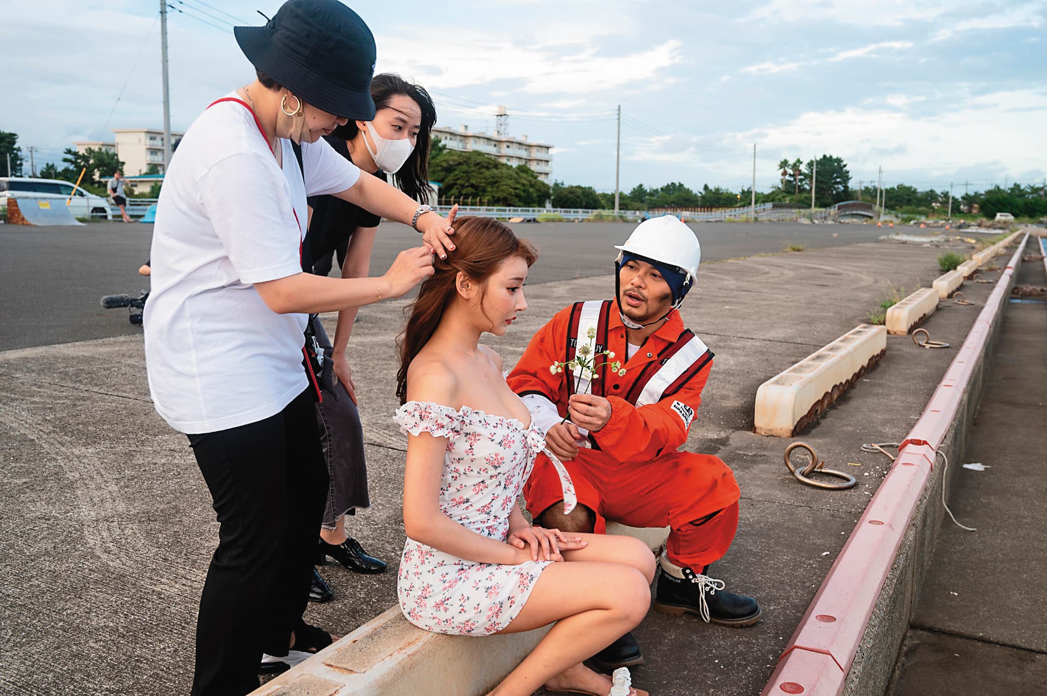 愛漂亮的明日花綺羅拍攝時隨時調整妝容髮型,黃明志拿著小花逗美女開心。(翻攝自黃明志臉書)